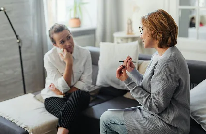 Terapeuta conversa con una paciente durante una consulta