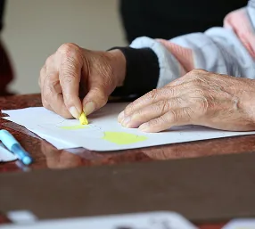 Persona mayor pinta durante una sesión de arte terapéutico